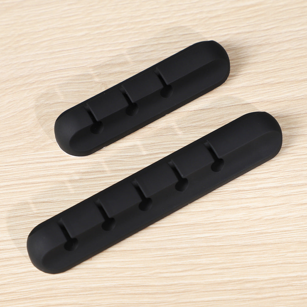 Two black rubber door stoppers on a wooden surface