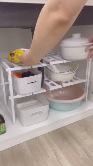 Person using a kitchen shelf organizer with various dishes and containers.