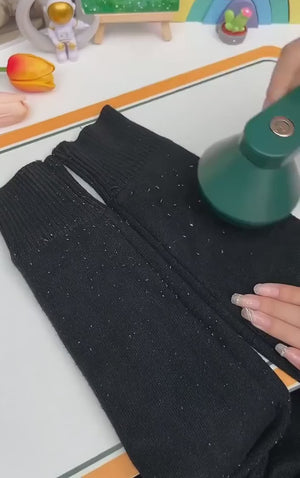 Person using a green spray bottle on black fabric with colorful background