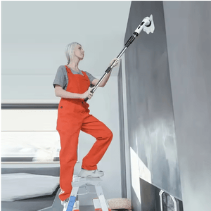 Person cleaning a wall with a high-pressure washer in an indoor setting