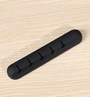Black rubber mat with multiple holes on a light wood surface